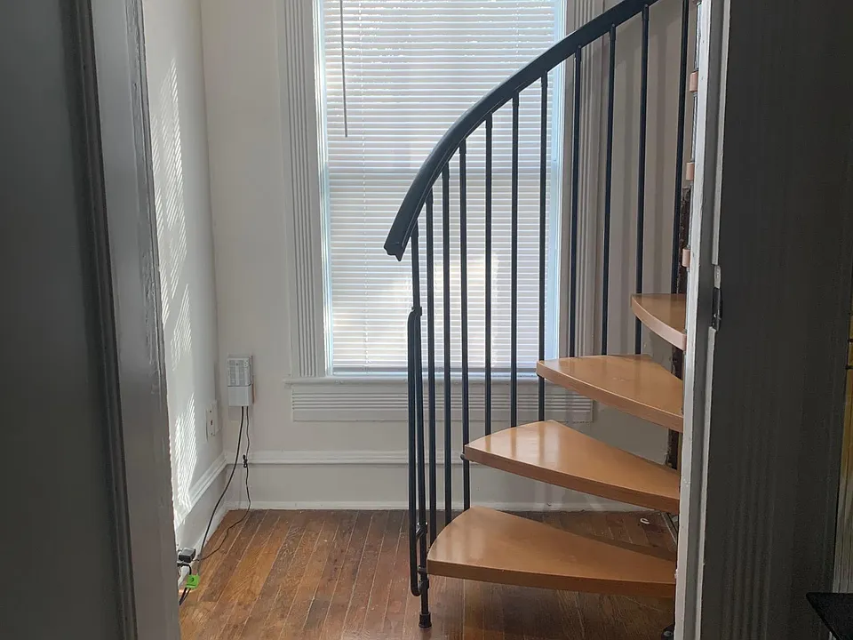 Entrance into apartment, stairs up to living area, laundry room on the right