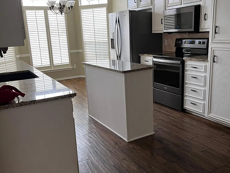 View of large open kitchen area. Windows are large enough for a breakfast table or comfortable morning coffee .
