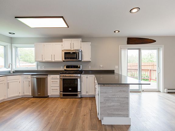 Freshly remodeled kitchen including new lighting, cabinets, sink, fixtures, flooring and fridge - all upgraded in 2021 & 2022.