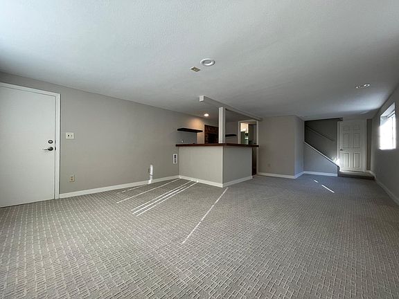 Living Area, with kitchen to the back left, and door to Bedroom 1, back right. Bedroom 2 door on left.