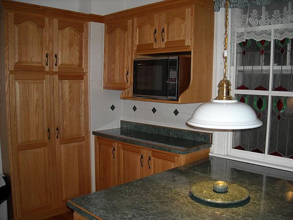 island/kitchen table with additional cabinets and tall pantry. Stained glass insert provides privacy from back porch.