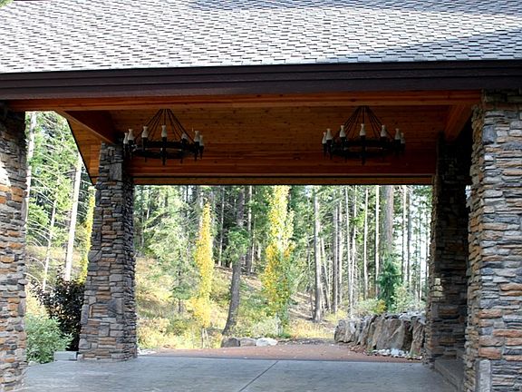 Grand portico provides protection from the elements as you enter the home along the paved and staine