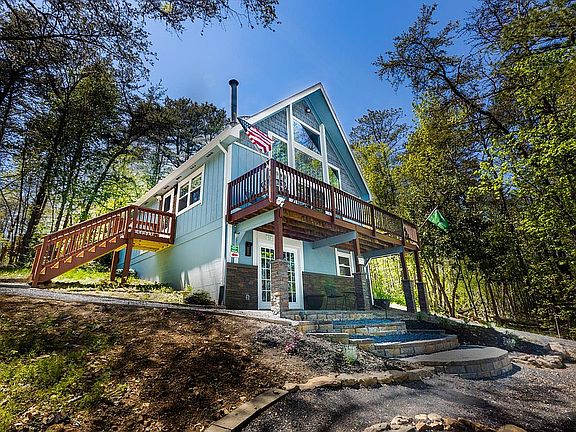 Stone-work arc steps, retaining wall, wain-scotting, pillars, and door surround, with shake shingles on the prow. Pines rustle and sway in the breeze. Birds and wildlife are likely to pass through at any time.