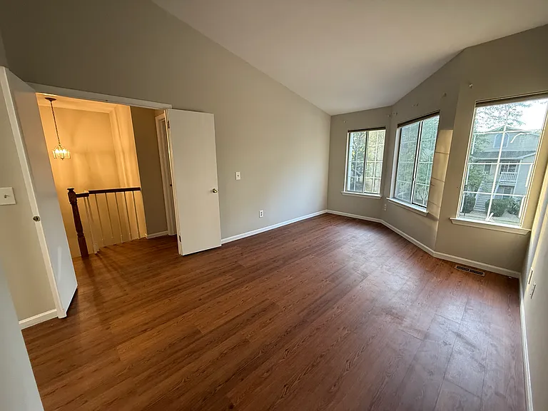 Master bedroom with LVP flooring, vaulted ceilings and loads of natural light