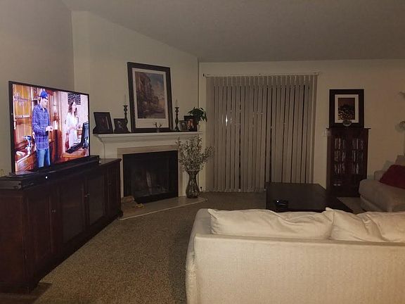 Living room with wood burning fireplace and doors to private balcony