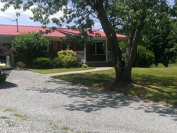 Front yard has nice landscaping, flowering bushes and a cove
