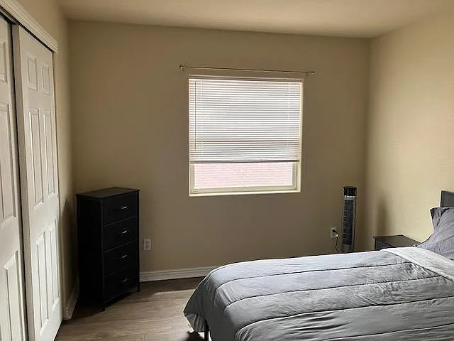 Private bedroom featuring a wide window with blinds, a sliding-door closet, and space for a full/queen bed and dresser. - W Nevada Pl