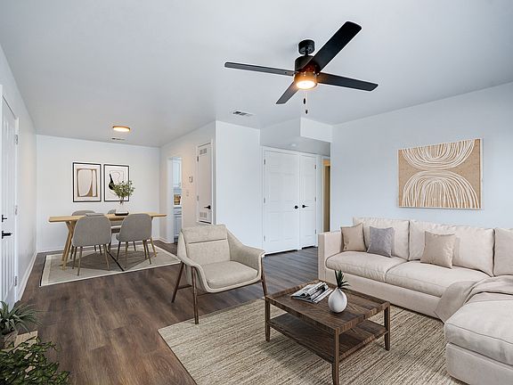 An open concept living room is shown at ReNew on Cantrell featuring modern furniture and ceiling fan.