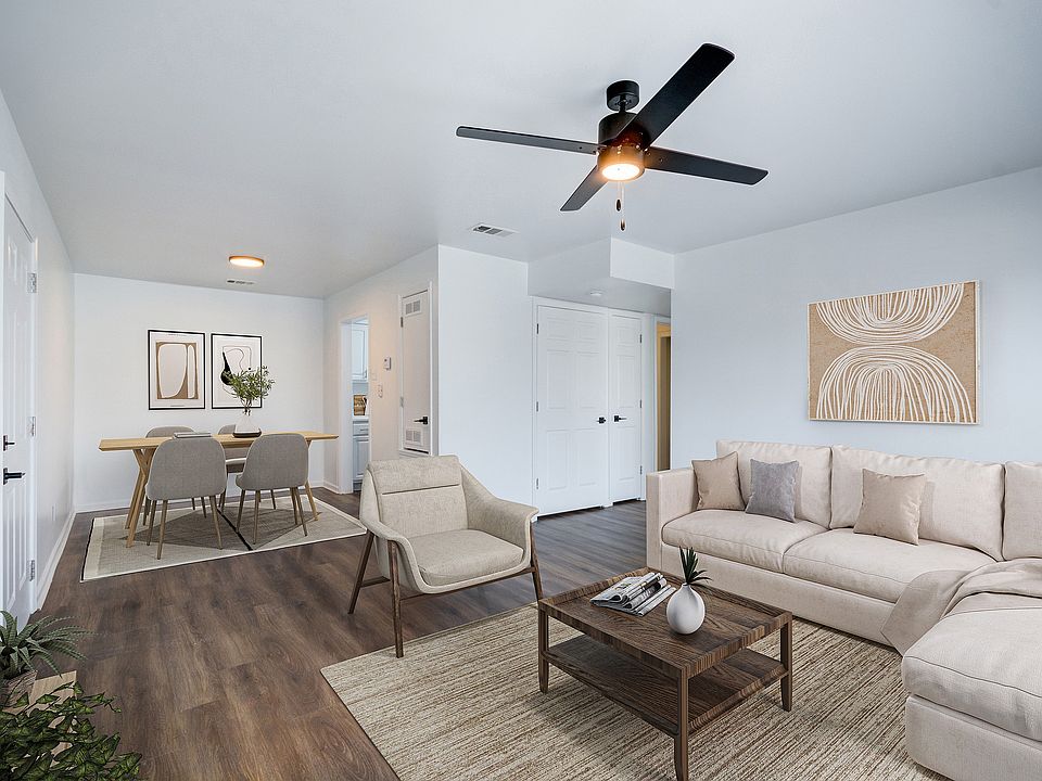 An open concept living room is shown at ReNew on Cantrell featuring modern furniture and ceiling fan.