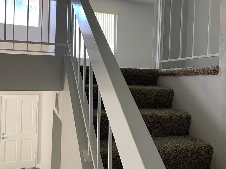 Stairway access to second level with primary bedroom, second bedroom and bathroom.