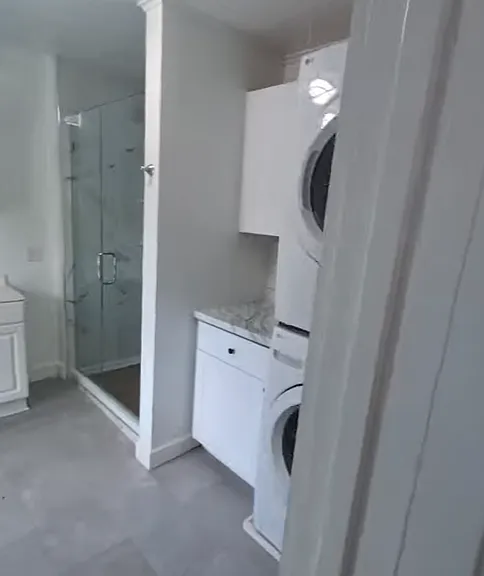 Shower and laundry area inside bathroom.