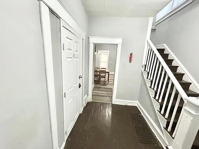Entry hallway with staircase and direct access to the dining area, featuring neutral walls and durable flooring.
