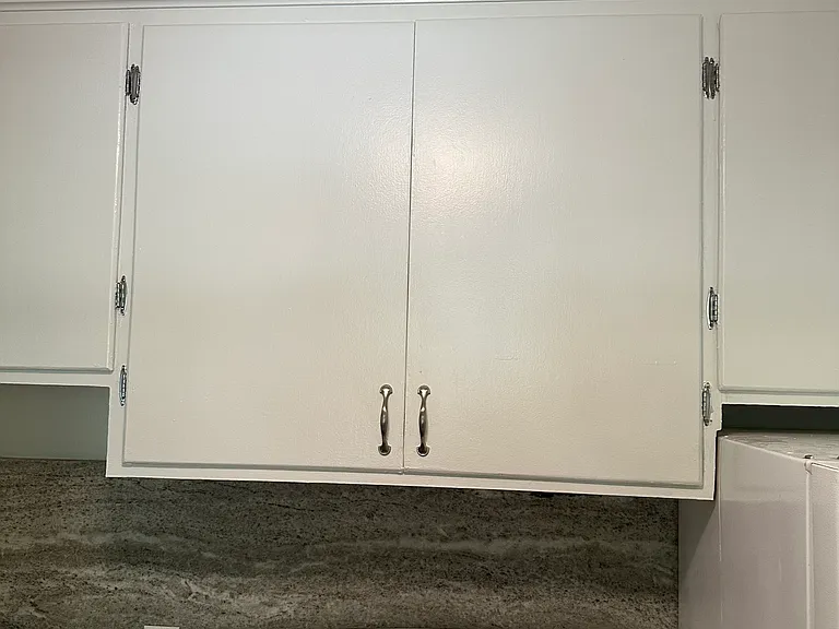 Lots of storage cabinets in galley kitchen, also freshly painted