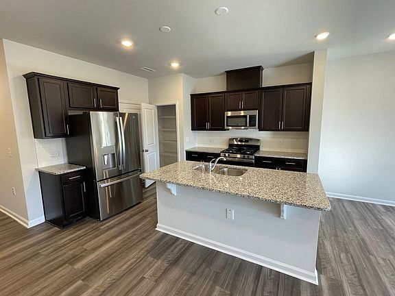 Kitchen with gas stove, microwave, fridge, granite counter tops, and a nice sized pantry