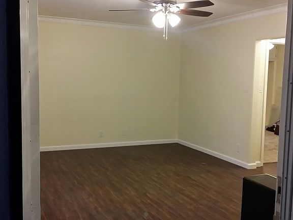 Large living room with ceiling fan and laminate floors