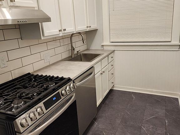 One side of the kitchen with new appliances, floors, counter tops.