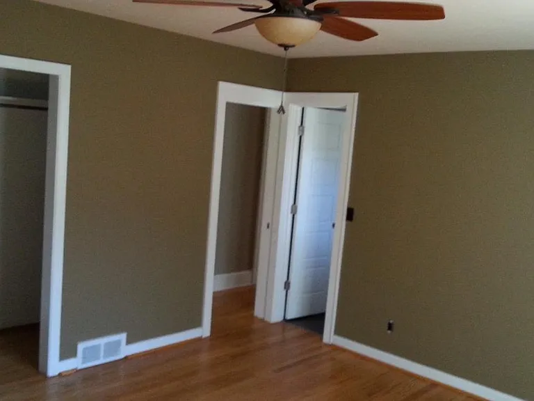 Master Bedroom with master bathroom that includes a tiled shower. Windows look out to the front yard and side.