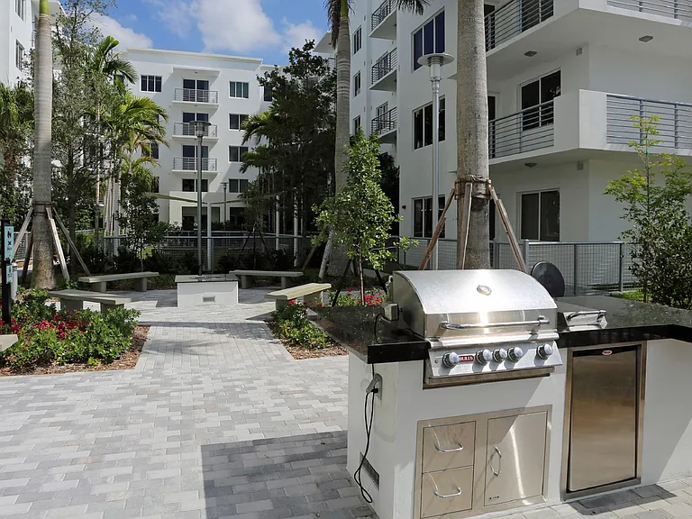 Outdoor community gardens with BBQ grills, lounge areas and a fire pit.