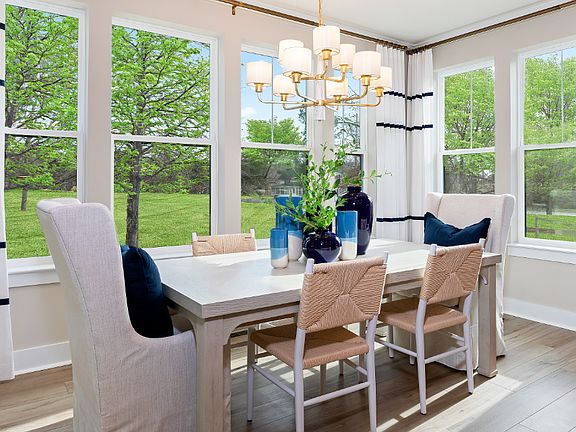 Dining area surrounded by window in a DRB Homes Barbados model home in The Estuary Community.
