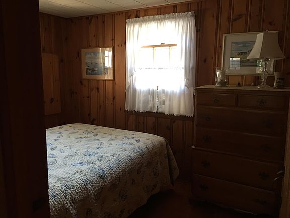 First floor bedroom with queen size bed, dresser, and a closet for hanging and storage.