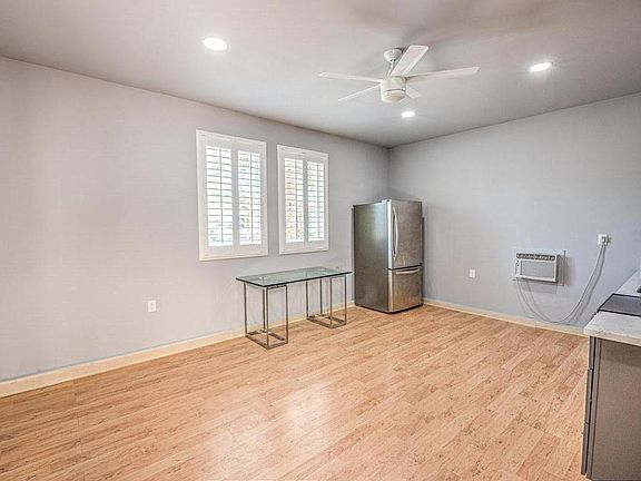 View of apartment as you walk in front entrance. Windows facing street, 22 cf LG refrigerator, through-wall a/c and 65" TV (to be installed).