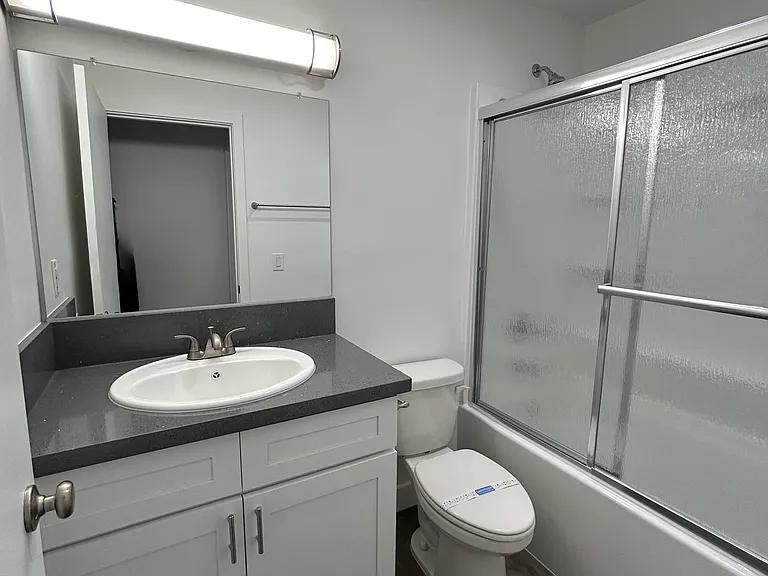 Bath with tub/shower combo and vanity for storage