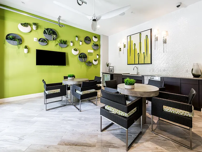 Resident lounge area with tables, chairs and satellite TV