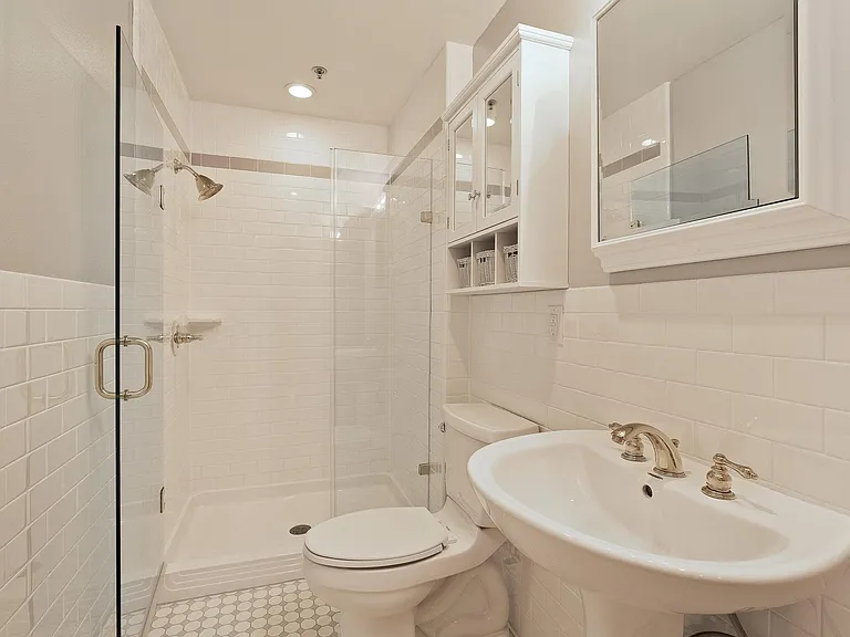A2 & A3 Floorplans - Guest Bathroom with frameless glass door, classic tile, and brass finishes.
