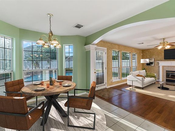 Virtual staging. Breakfast room opens to den with fireplace.