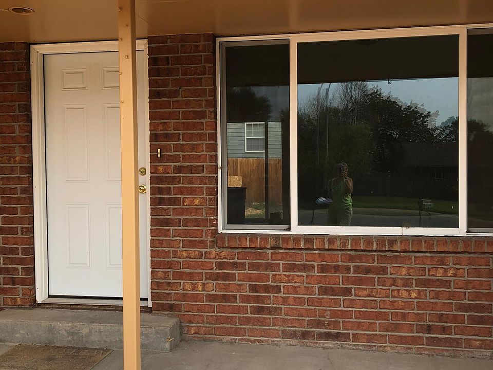 Front door and living room window. Garage access to the right.