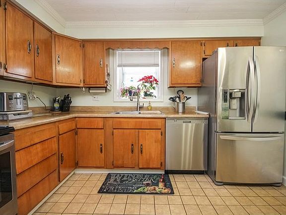 High End newer stainless steal appliances with ceramic tile flooring