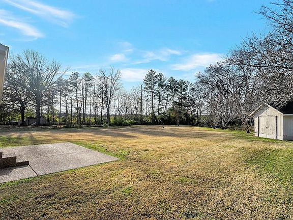 Back yard with detached Storage Unit. Winter Dormant Grass