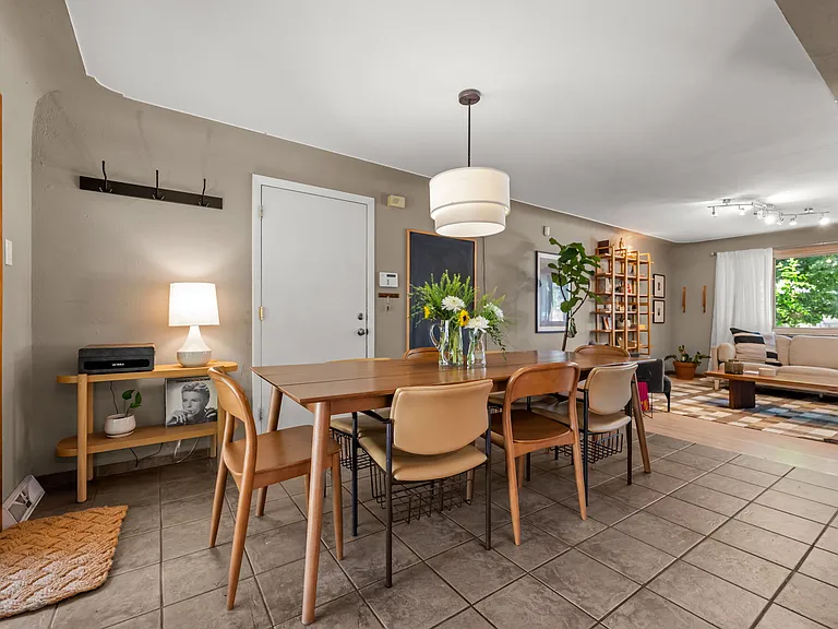 Dining area with door to side patio and fenced yard. Opens to kitchen and living area.