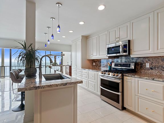 High-end renovation includes opulent open kitchen with custom cabinets, highest-end stainless steel appliances, rare expansive kitchen island, all with fantastic ocean views.