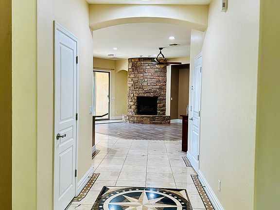 Hallway leading to kitchen and family room with fire place. Coat closet on your left and walk-in pantry on your right