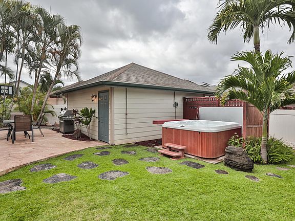 Two car garage, patio and stepping stones leading towards outdoor shed