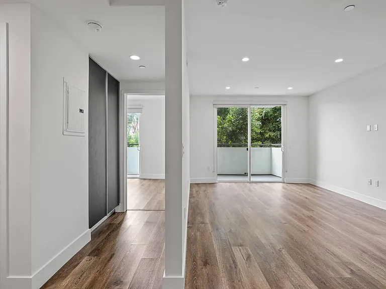 Hallway with Built-In Cabinet Storage and Living Room with Patio