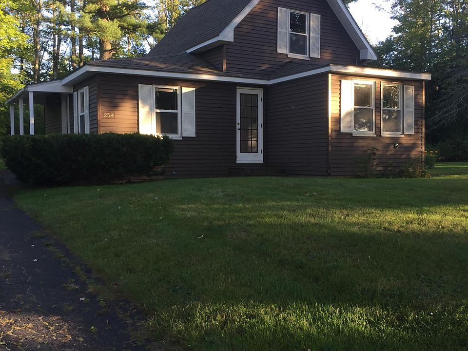 View of the front of the house from street. driveway on left. Main entrance under the covered porch on left