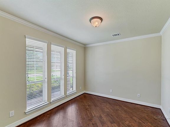 Study up front with abundant light and wood flooring.
