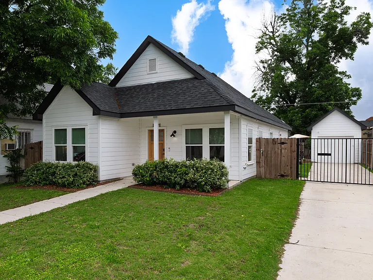 Front yard with driveway and gate to the right.