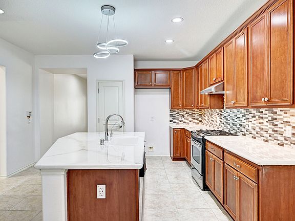 Open kitchen with huge stainless steel appliances and huge island with double sink for added convenience.