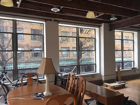 TWO walls of floor-to-ceiling vintage windows and open wood-beamed ceilings