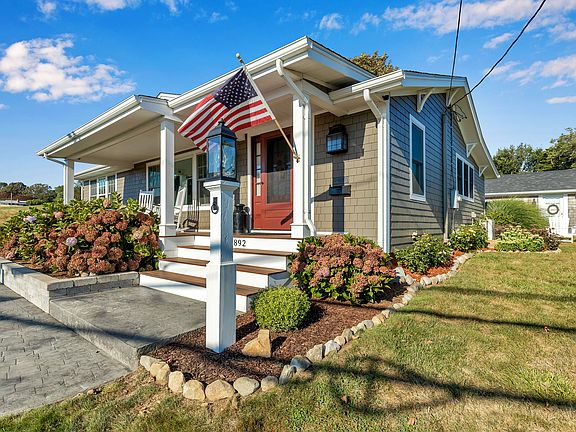 A stamped concrete walk way, Azek Trim, Hardiboard Shingles, and a covered Ipe front porch create a welcoming entrance.