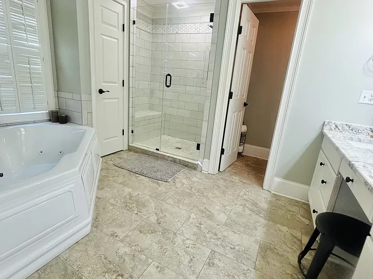 On suite bath features large stand-up shower with bench, granite countertops, jetted tub, double sinks, vanity and private water closet!