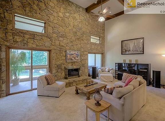 Two story family room, stone wall fireplace, bar area.