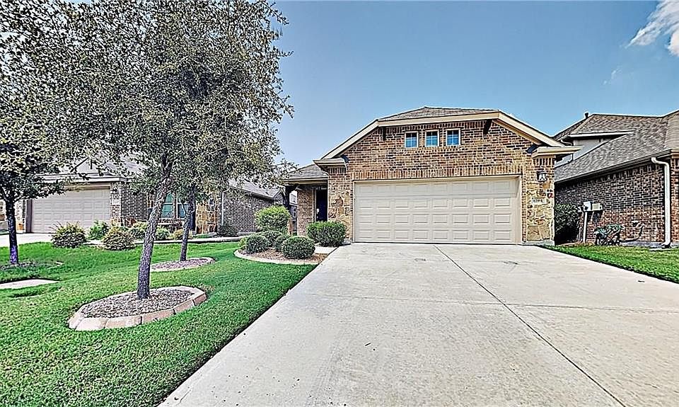 View of front of property featuring a garage and a front yard