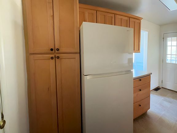 Convenient layout with full-size refrigerator, additional cabinetry, and deck access.