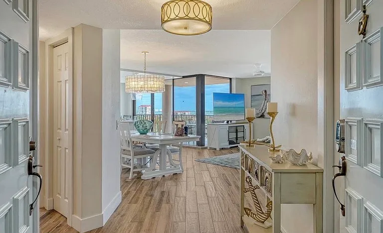 Feel the start of your coastal vacation as you walk through the double doors. Completely remodeled - wood look tile throughout, plantation shutters, professionally decorated, surrounded by water views, sunsets, and sunrises. LOCATION, LOCATION, LOCATION