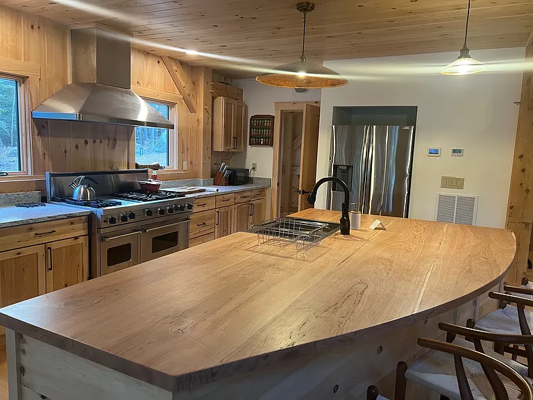 Kitchen cherry island and stove to the left. Sink is in island.