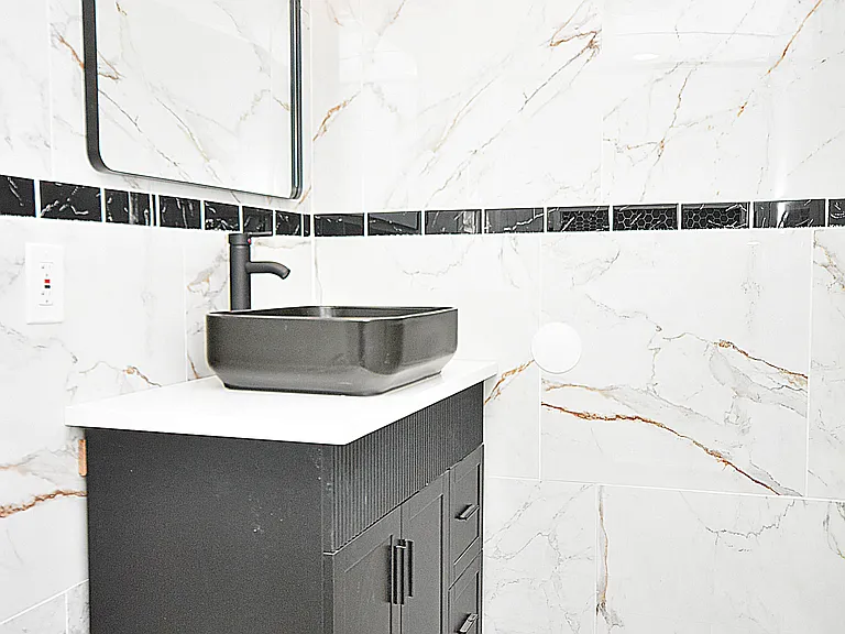 Sleek bathroom vanity with designer sink and wall mirror.